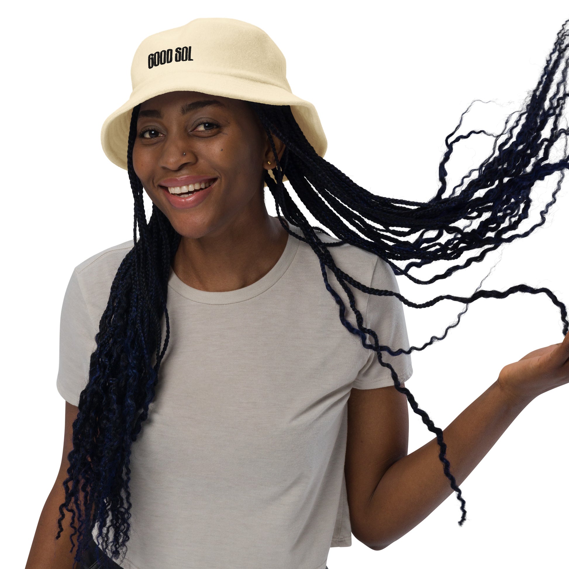 Black woman with a gray shirt with a yellow terry cloth bucket hat. The word Good Sol is threaded at the top.